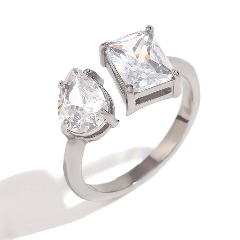 Open ring featuring a large droplet crystal and a square crystal, merging modern flair with timeless sophistication, ideal for enhancing any outfit with a touch of glamour.