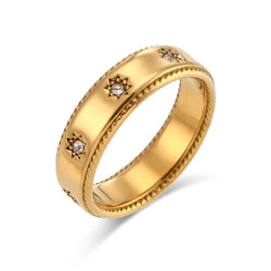 "Close-up of a gold band ring adorned with crystal stars, creating a celestial and enchanting effect."