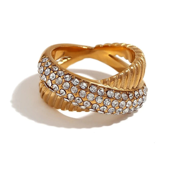 "Close-up of a crossover ring with one half encrusted in cubic zirconia crystals and the other half striped, showcasing elegance and sparkle in its design."