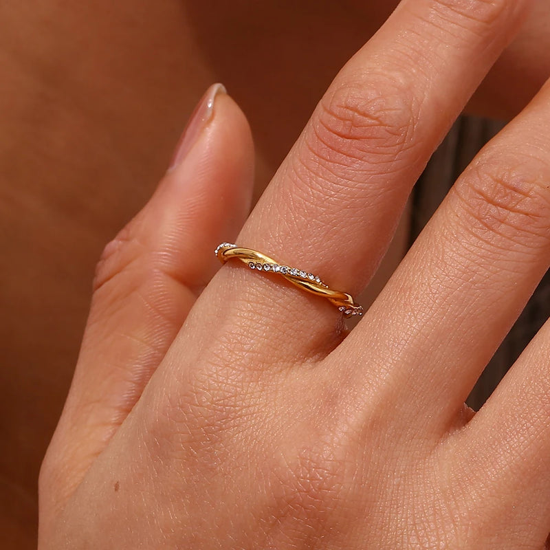 "Close-up of a thin braided band ring with one band encrusted with cubic zirconia stones, offering a blend of elegance and sparkle."