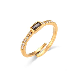 "Close-up of a ring with a rectangular onyx stone set on a thin band encrusted with cubic zirconia, combining elegance and sophistication."